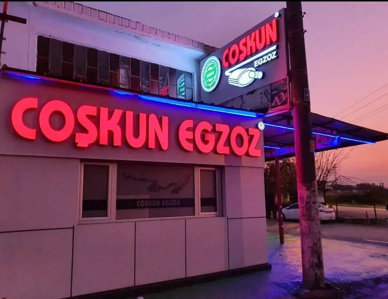 Akşam ışığında Coşkun Egzoz tabelası ve işletme binası