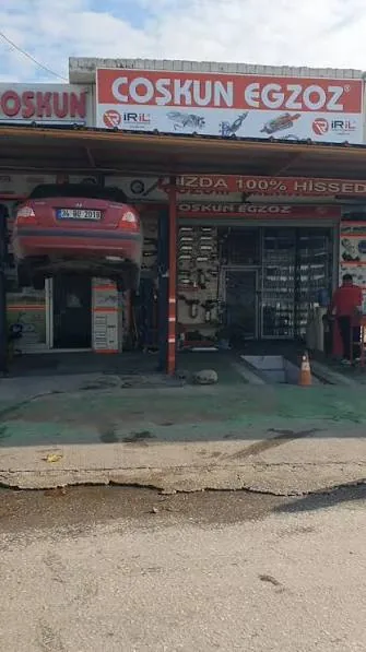 Coşkun Egzoz işletmesinin önünde lifte kaldırılmış bir araç